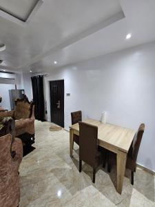 Serene Oasis في Ikorodu: غرفة طعام مع طاولة وكراسي خشبية