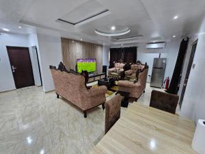 Serene Oasis في Ikorodu: غرفة معيشة مع كراسي وتلفزيون بشاشة مسطحة