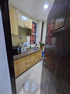 La cuisine est équipée d'un évier et d'un grand réfrigérateur brun. dans l'établissement Serene Oasis, à Ikorodu