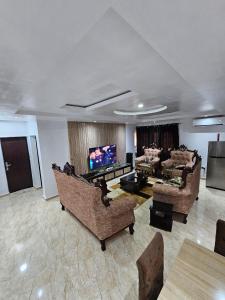Serene Oasis في Ikorodu: غرفة معيشة مع كنب وتلفزيون بشاشة مسطحة