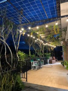 un patio con luces, mesa y sillas en SATURDAY Homestay Tuy Hòa - Phú Yên en Tuy An
