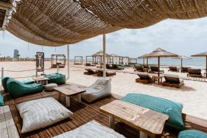 einen Strand mit Tischen und Sonnenschirmen am Strand in der Unterkunft Villa Ioanna - 50m from Med Sea in Ayia Napa
