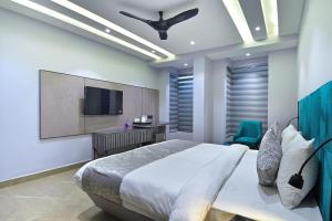 a bedroom with a bed and a flat screen tv at Hotel Uptown Delhi - By La Exito Hotels in New Delhi