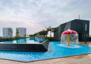 een groot zwembad met een rode parasol in het midden bij Tranquil Suite, MKH Boulevard 2 in Kajang