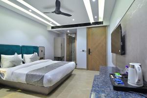 um quarto com uma cama e uma televisão de ecrã plano em Hotel Uptown - Near New Delhi Railway Station - Paharganj em Nova Deli