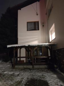 a building with a bench in front of it at night at Alfa 2 apartament 3 in Bystra +16 photos