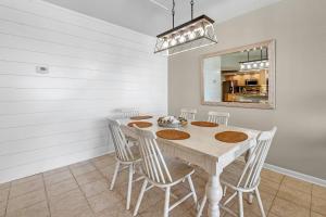 - une salle à manger avec une table, des chaises et un miroir dans l'établissement Summer House 405A, à Romar Beach