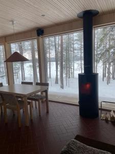 a fireplace in a room with a table and a stove at A unique lakeside cottage in Rovaniemi