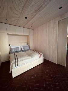 Schlafzimmer mit einem Bett mit Holzdecke in der Unterkunft A unique lakeside cottage in Rovaniemi
