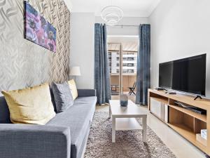 a living room with a couch and a tv at Brand New 1BDR Dubai Marina -Close to Metro in Dubai