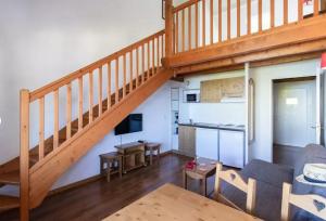 ein Wohnzimmer mit einer Treppe, einem Sofa und einem Tisch in der Unterkunft Duplex-Chalet entre Lac et Montagne - Balcon Vue Lac in Lugrin
