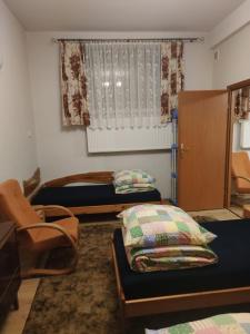 a room with two beds and a chair and a window at Alfa 2 apartament 3 in Bystra