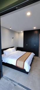 a bedroom with a large bed with white sheets at Novaworld Phan Thiết- 7Days mart in Phan Thiet
