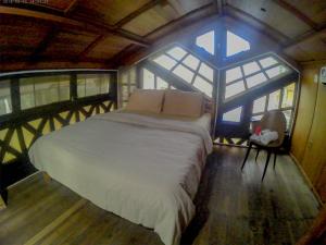 Bett in einem Zimmer mit einem großen Fenster in der Unterkunft Karang Aji Beach Villa in Cisolok
