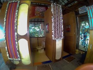 ein Bad mit WC in einem Zimmer mit Vorhängen in der Unterkunft Karang Aji Beach Villa in Cisolok