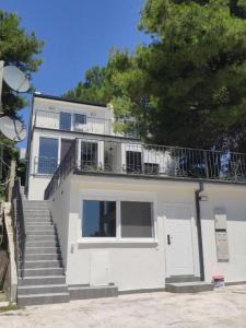 Digital Nomads Apartments في بار: بيت ابيض فيه درج وبلكونه