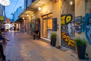 a street with people sitting outside of a building at Hoppersgr- Amazing apt in the heart of Athens - 4 in Athens