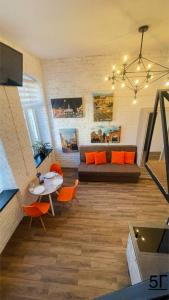uma sala de estar com um sofá, uma mesa e cadeiras em Квартира-студія в самому центрі міста біля Кобилянської em Chernivtsi