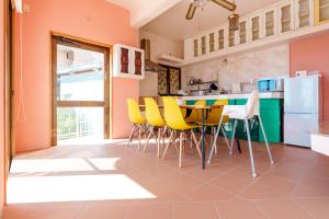 a kitchen with yellow chairs and a table at Tropical Soul Okinawa in Teruya