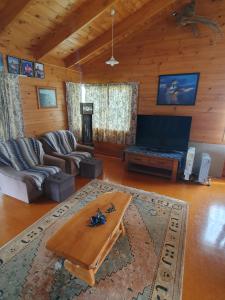 a living room with a couch and a table at Kirikiri Pawhaoa in Whangaruru