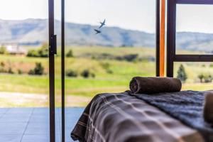 a room with a window with a view of a plane at Serenity at Cathkin Estate, Central Drakensberg in Winterton