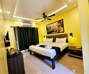 a bedroom with a bed and a ceiling fan at Hotel Adam's Baga Beach Resort Goa - 2 minutes walk from Baga Beach in Baga