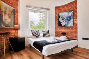 a bedroom with a bed and a brick wall at Hermosilla Prime, by Presidence Rentals in Madrid