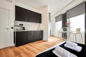 una cocina con armarios negros y un sofá en una habitación en Hermosilla Prime, by Presidence Rentals en Madrid