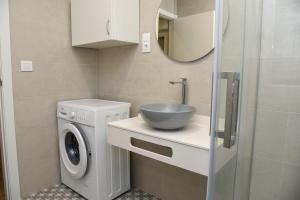 a bathroom with a sink and a washing machine at LA VILLA DE ORGAZ II in Toledo