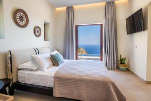 MerTelia Luxury Villas في Kyra Panagia: غرفة نوم مع سرير وإطلالة على المحيط