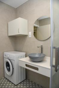 a bathroom with a washing machine and a sink at LA VILLA DE ORGAZ II in Toledo