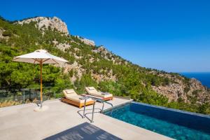a villa with a swimming pool and an umbrella at MerTelia Luxury Villas in Kyra Panagia