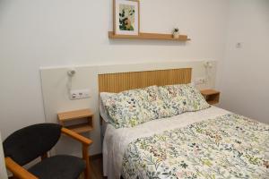 a small bedroom with a bed and two chairs at LA VILLA DE ORGAZ II in Toledo