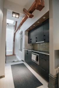 a kitchen with black cabinets and a black rug at Guldgränd in Stockholm