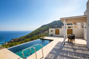 a villa with a swimming pool and a view of the ocean at MerTelia Luxury Villas in Kyra Panagia