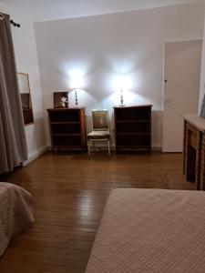 1 dormitorio con 2 vestidores, 1 cama y 1 silla en Charmant appartement au pied du château, en Gien