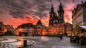 an old city with a sunset in the background at Center of Prague Apartment 369 in Prague