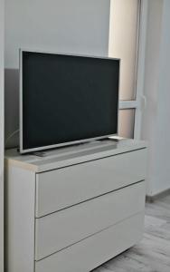 a flat screen tv sitting on top of a white dresser at Fortuna Park Apartman in Sfântu-Gheorghe