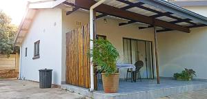 une terrasse couverte d'une maison avec une table et une plante dans l'établissement Pumula on 5th, à Pumula