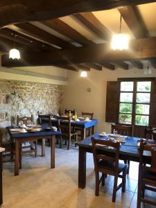 comedor con mesas y sillas y pared de piedra en Casa Rural Trebol4Hojas en San Pedro