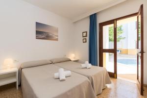 ein Schlafzimmer mit 2 Betten und Handtüchern darauf in der Unterkunft Apartamentos Casa del Sol in Cala Blanca