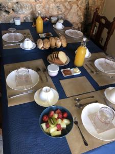 a table with plates of food and a bowl of fruit at Casa Rural Trebol4Hojas in San Pedro