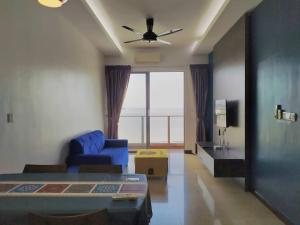 a bedroom with a blue couch and a ceiling fan at Silverscape Seaview Suite Melaka @ FREE WIFI in Melaka