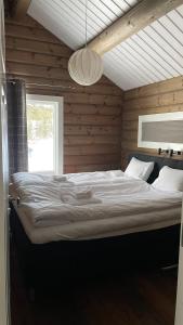 a bedroom with a large bed in a wooden wall at Åre Valley Lodges - Björnbergshyllan 9B in Åre