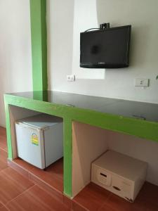 einen Tisch mit einem TV an der Wand und einer Box in der Unterkunft Bank Guesthouse in Haad Rin