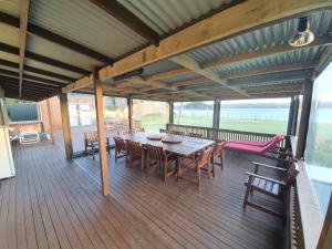 a wooden deck with a table and chairs on it at Kirikiri Pawhaoa in Whangaruru