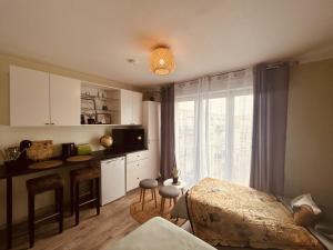 ein Schlafzimmer mit einem Bett und eine Küche mit einem Fenster in der Unterkunft LA MARIEFACTURE - Comme un Explorateur in Metz