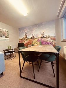 une salle à manger avec une table et une peinture d'une ferme dans l'établissement LA MARIEFACTURE - Comme à Amsterdam, à Saint-Avold