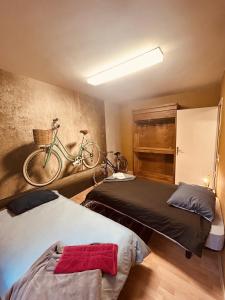 - une chambre avec 2 lits et un vélo sur le mur dans l'établissement LA MARIEFACTURE - Comme à Amsterdam, à Saint-Avold