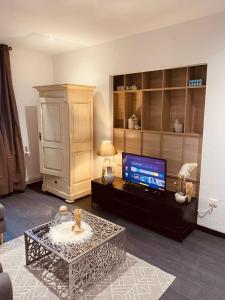 uma sala de estar com uma televisão e uma mesa de centro em LA MARIEFACTURE - Comme un Nid Douillet 